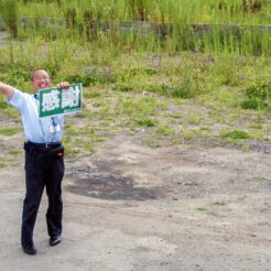 2012-08-13-12-17-58荒廃した鵜住居地区に立って訪れた人に向かって感謝と書かれたボードを掲げる語り部の方<br>仙台から松島を経て南三陸に泊まり、志津川や釜石・宮古・小本までの震災の傷跡をみる旅