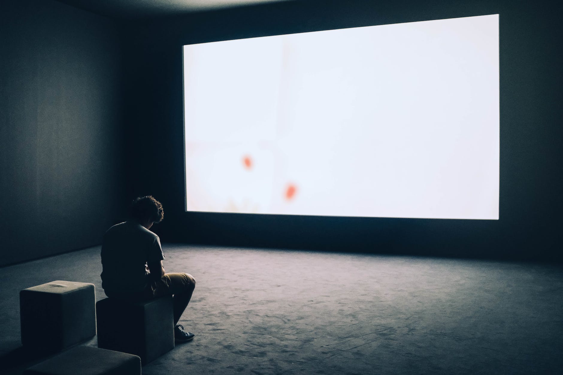 man sitting in front of turned on screen