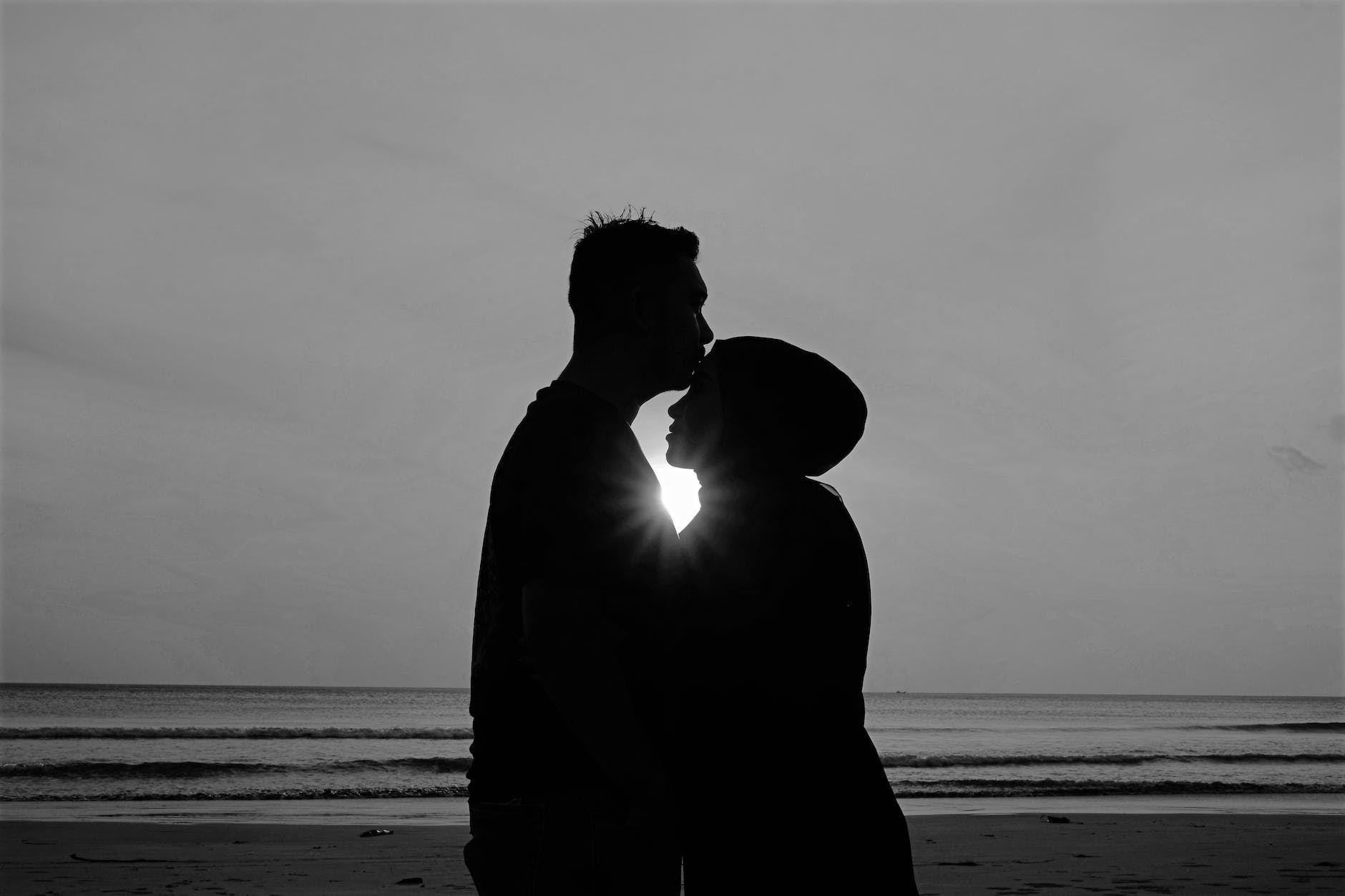 silhouette of man and woman standing on beach