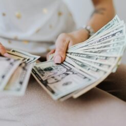 person holding fan of us dollar bills
