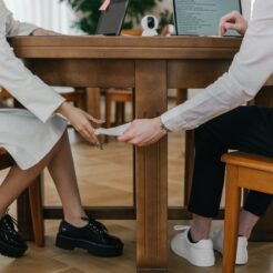 a student passing notes under the table to another person